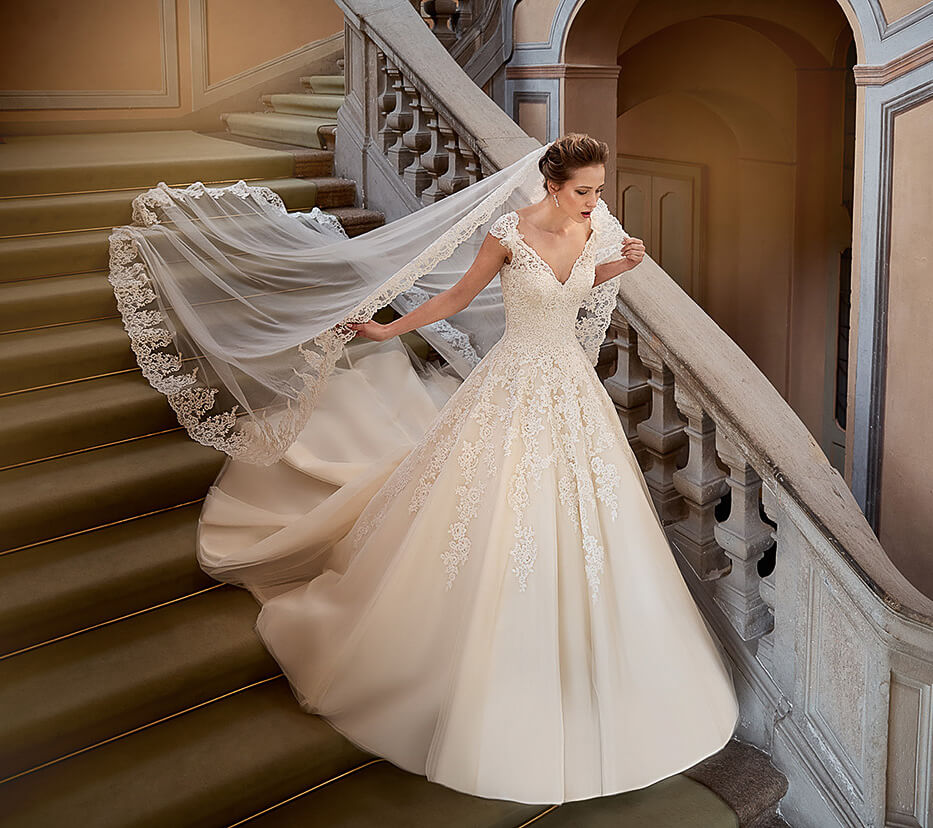 Braut auf einer Treppe mit langem Schleier und Kleid in A-Linie