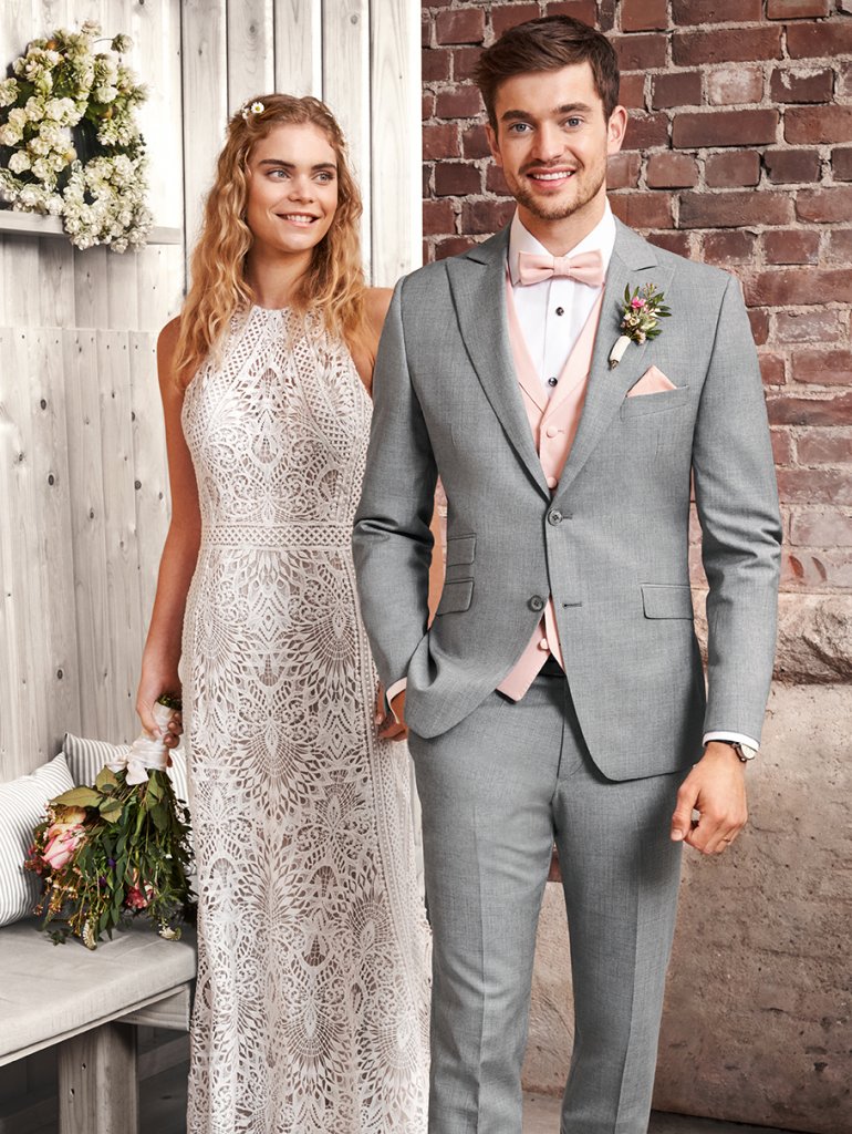 Braut in Boho-Kleid und Bräutigam mit grauem Sacko