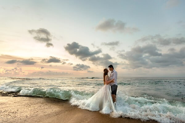 Brautpaar am Strand in den Wellen stehend